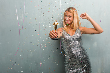 Elegant blonde woman receiving an award, celebration with confetti.