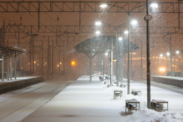 Empty railway platform without passengers in blizzard/heavy snowfall at night. Railway, bad weather concept