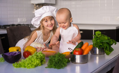 little girl and boy, white chef hat, vegetables