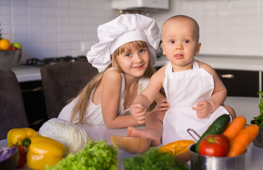  little girl and boy, white chef hat, vegetables