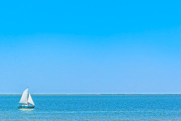 Obraz premium Sailboat in the blue sea on a sunny summer day