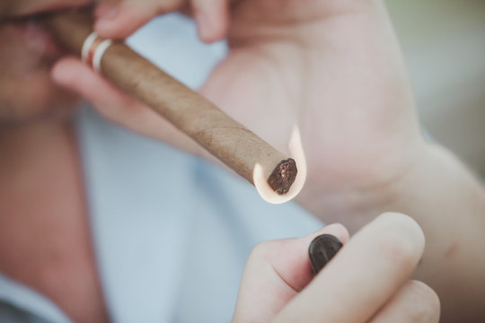 The man sets fire to a cigar
