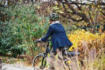 Unrecognizable active senior woman with electrobike cycling outdoors in park.