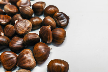 Chestnuts on a blank (white) background. Pile of fresh chestnuts ready to roast shot over white background