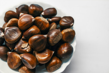 Chestnuts on a blank (white) background. Pile of fresh chestnuts ready to roast shot over white background