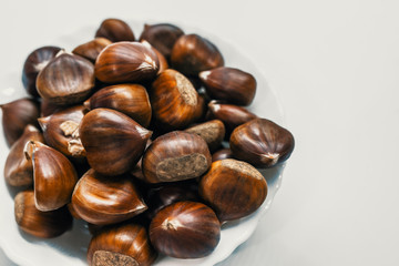 Chestnuts on a blank (white) background. Pile of fresh chestnuts ready to roast shot over white background