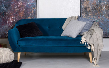 Navy blue retro sofa with cushions and gray blanket