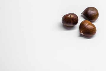 Chestnuts on a blank (white) background. Pile of fresh chestnuts ready to roast shot over white background