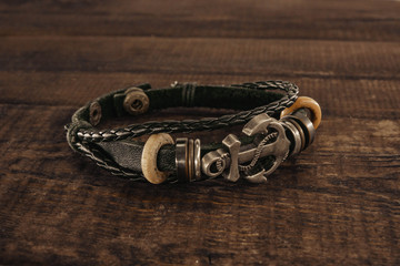bracelet with an anchor sign. anchor lying on a wooden background © taiga