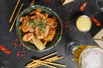Beer mug, grilled shrimps, sausages and pretzel on wooden table. Top view