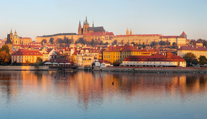 Naklejka na ściany i meble Prague - The Mala Strana, Castle and Cathedral from promenade over the Vltava river in the morning light.