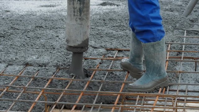 Video of concrete mix poured into formwork on a building construction site.