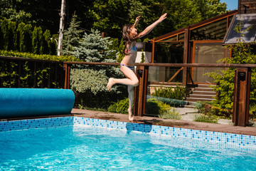 Naklejka premium Happy girl jumping in the the pool