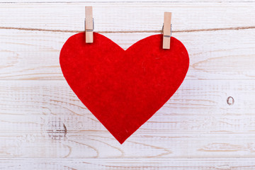 Red hearts on a rope with clothespins, on a white wooden background. Place for text, copy space.