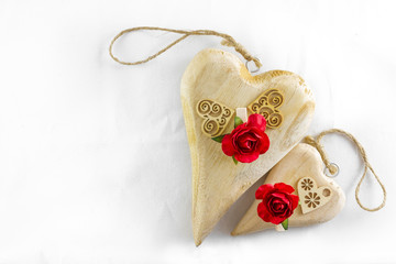 Wooden hearts and red rose on white for Valentines Day