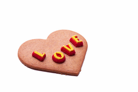 A heart shaped gingerbread cookie with a decoration that says I LOVE YOU