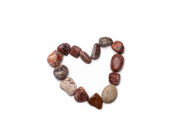 A heart shape made with pebbles on white