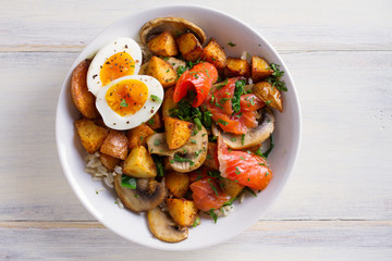 Healthy food bowl: salmon, eggs, potatoes, mushrooms, rice and spinach on white wooden table. overhead, horizontal