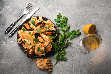Mussels, bread toasts and white wine on stone table. Top view with copy space.