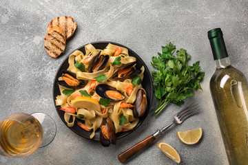 Mussels, bread toasts and white wine on stone table. Top view with copy space.