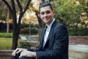 Fototapeta premium Close up Businessman of smiling sitting on park stairs