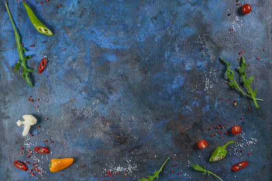 Selection of spices herbs and greens. Ingredients for cooking. Food background on blue nable. Top view copy space.