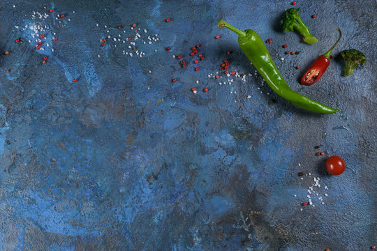 Selection of spices herbs and greens. Ingredients for cooking. Food background on blue nable. Top view copy space.