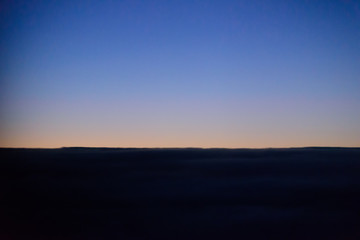 The blue skyline with cloudy in sunrise time, view from window on the plane.