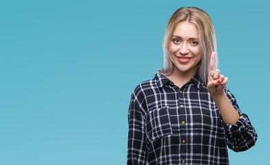 Young blonde woman over isolated background showing and pointing up with finger number one while smiling confident and happy.