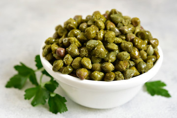 Marinated capers in a white bowl.