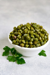 Marinated capers in a white bowl.
