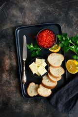 Red salmon caviar, baguette and butter for making delicious sandwich.Top view with copy space.