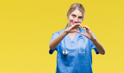 Young beautiful blonde doctor surgeon nurse woman over isolated background smiling in love showing...