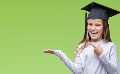 Young beautiful girl wearing graduate cap over isolated background amazed and smiling to the camera...