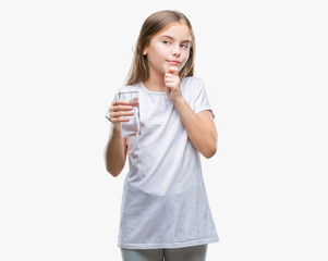 Young beautiful girl drinking glass of water over isolated background serious face thinking about question, very confused idea