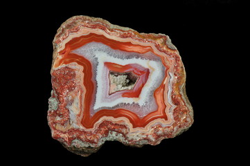 A cross section of the agate. Red shades in the outer part. In the center gray, transparent quartz....