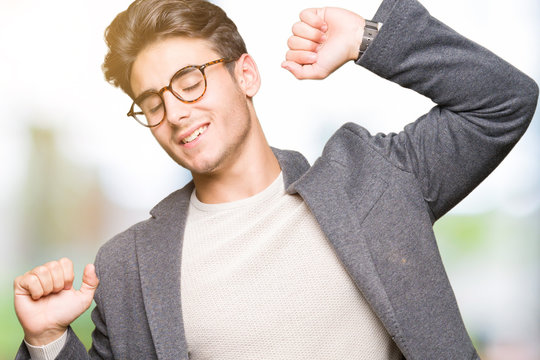 Young business man wearing glasses over isolated background stretching back, tired and relaxed, sleepy and yawning for early morning