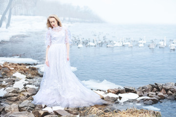 Fototapeta na wymiar girl in a vintage dress on a river in winter