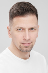 Obraz premium Futuristic handsome bearded brunet man 40s years in white clothes on a white background close-up. God, teacher and boss.