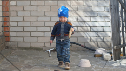 Little boy with camera and bread outdoors near wall