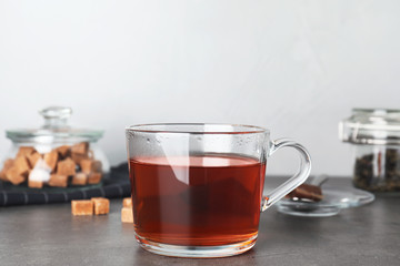 Cup of hot tea on table against blurred background