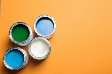 Flat lay composition with paint cans and space for text on color background