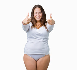 Beautiful plus size young overwight woman wearing white underwear over isolated background doing happy thumbs up gesture with hand. Approving expression looking at the camera showing success.