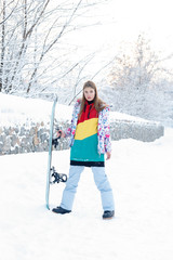 Fototapeta na wymiar woman winter outdoor snowboarding concept. Young woman holding snowboard on her shoulders, she's looking away and smiling, copy space, close up