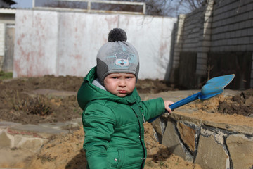 Little boy playing with toy spade outdoors