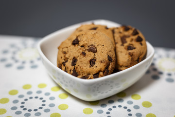 Close-up view of chocolate chip cookies in a white bowl.