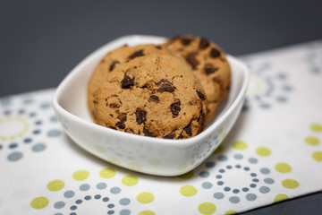 Close-up view of chocolate chip cookies in a white bowl.