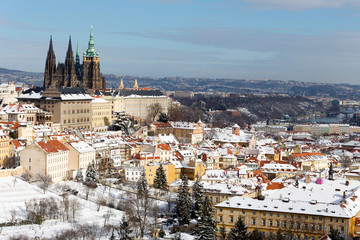 Obraz premium Snowy Prague City with gothic Castle from Hill Petrin in the sunny Day, Czech republic