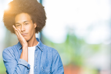 Young african american man with afro hair thinking looking tired and bored with depression problems with crossed arms.