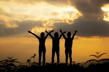 Silhouette, group of happy girl playing on hill, sunset, summertime